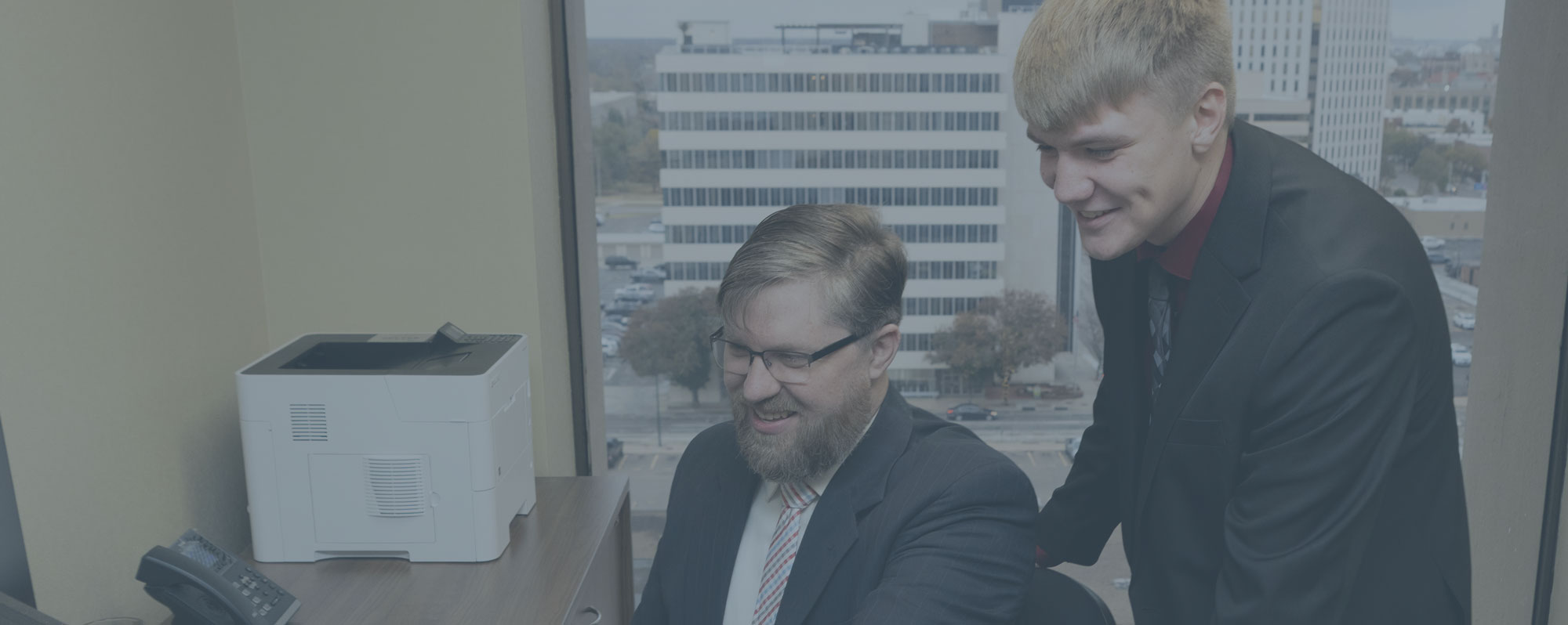 two larson and company employees looking at computer monitor